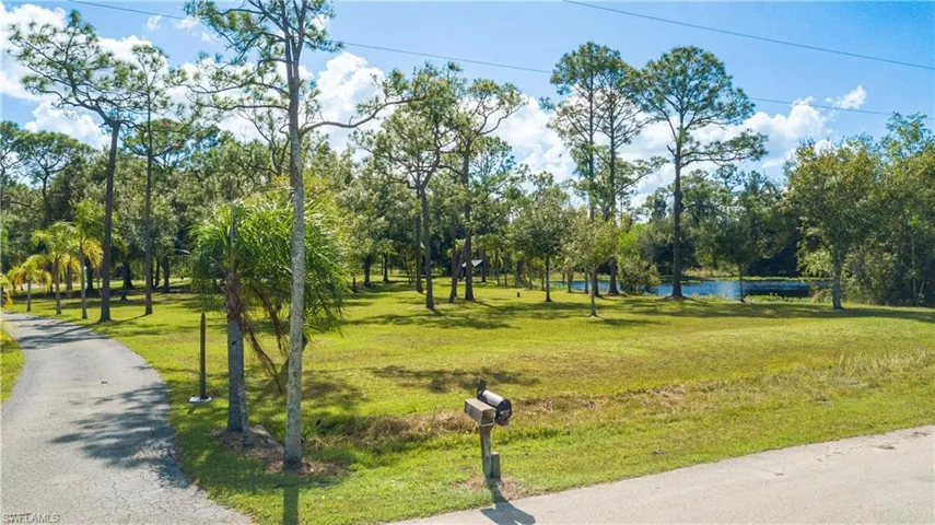 Private Winding Palm Tree Lined Entrance Into The Heart Of This Secluded 5 Acre Parcel. Included In This Paradise Is A Shimmering .75/Acre Private Lake.