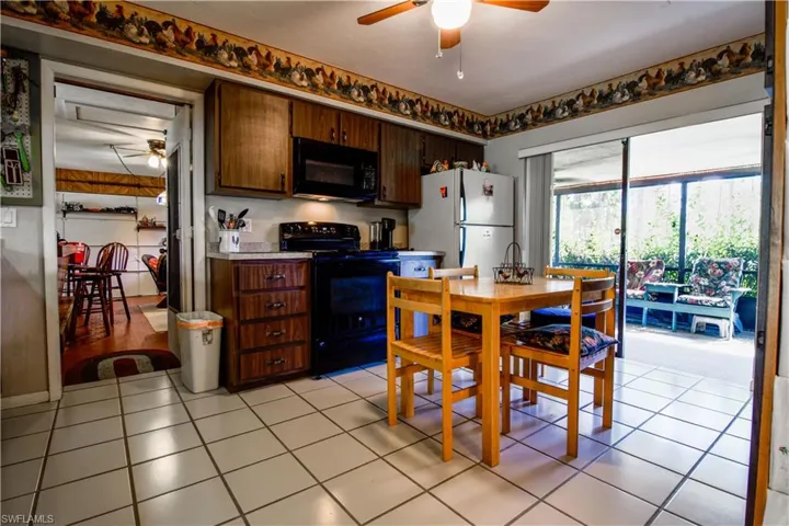 Warm And Homey Kitchen With Tiled Floors, Entry Into The Bonus Room With A Bar, Sliders To The Huge Screened Lanai.