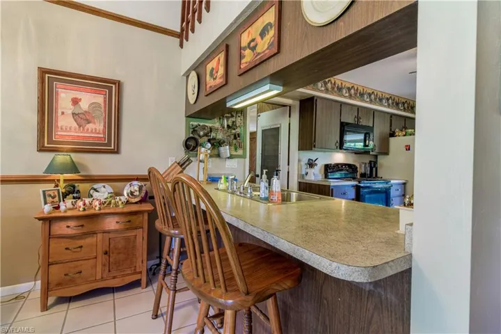 Dining Area Of The Great Room With Views Of The Lake And Circular Driveway. Featuring Soaring Ceilings And A Breakfast Bar Into The Kitchen.