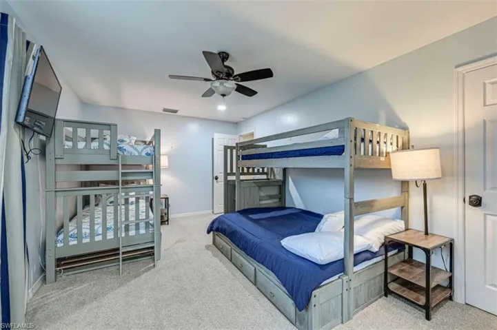 Bedroom with ceiling fan and light carpet