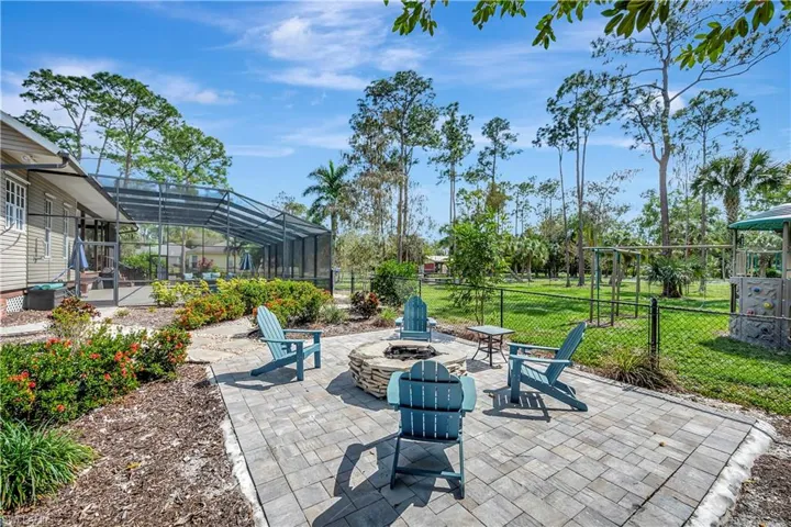 View of patio featuring glass enclosure and an outdoor fire pit