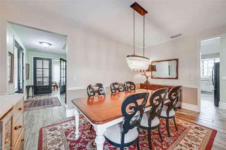Dining space featuring a notable chandelier, french doors, and light hardwood / wood-style flooring