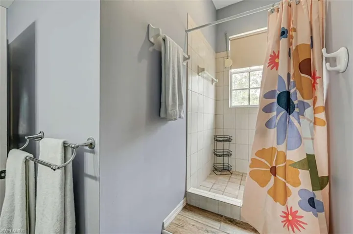 Bathroom with hardwood / wood-style flooring and a shower with curtain