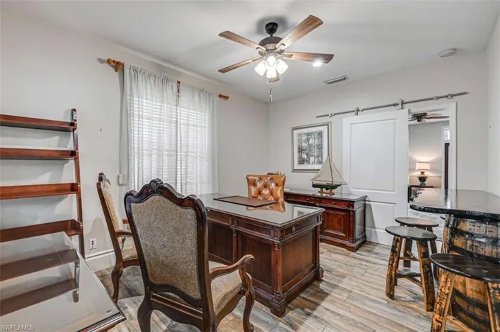 Office space with light hardwood / wood-style flooring and ceiling fan