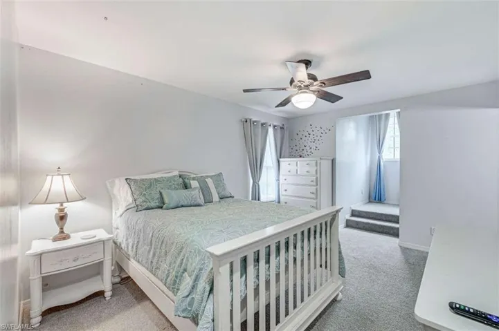 Carpeted bedroom featuring ceiling fan