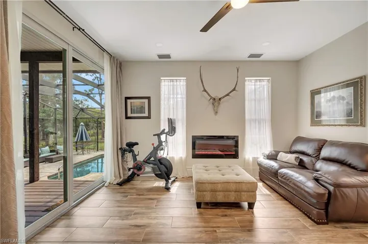 Living room with ceiling fan, a wealth of natural light, and light hardwood / wood-style floors