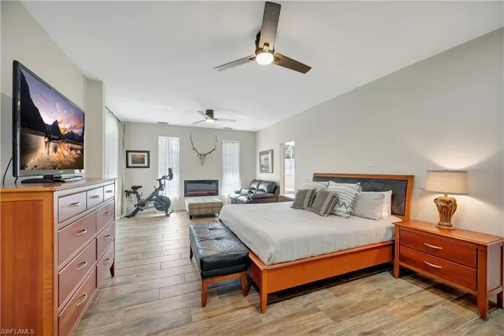 Bedroom featuring multiple windows, light wood-type flooring, and ceiling fan
