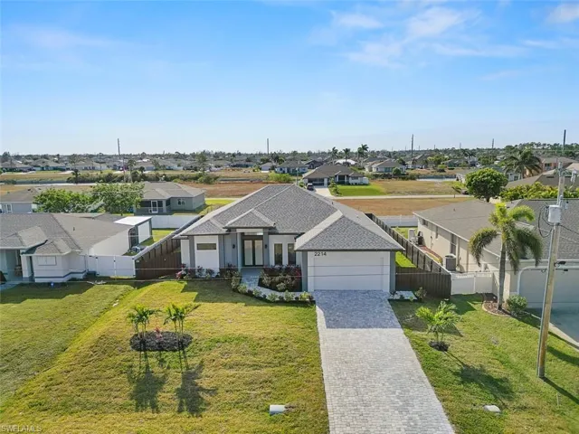 View of front of property featuring a residential view, decorative driveway, and an attached garage