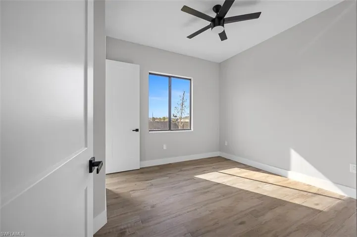 Empty room with wood finished floors and a ceiling fan