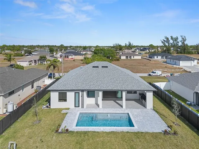 Back of house featuring stucco siding, a residential view, a fenced backyard, a shingled roof, and a patio