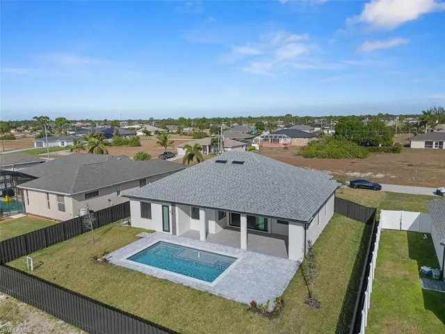 View of swimming pool featuring a patio, a residential view, a fenced backyard, and a jacuzzi