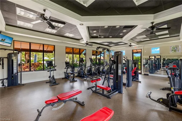 Gym with ceiling fan, coffered ceiling, and ornamental molding