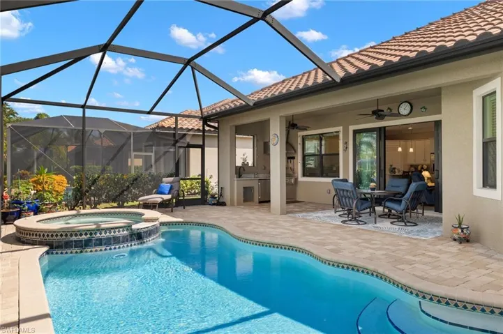 View of pool with a lanai, area for grilling, ceiling fan, and a patio area