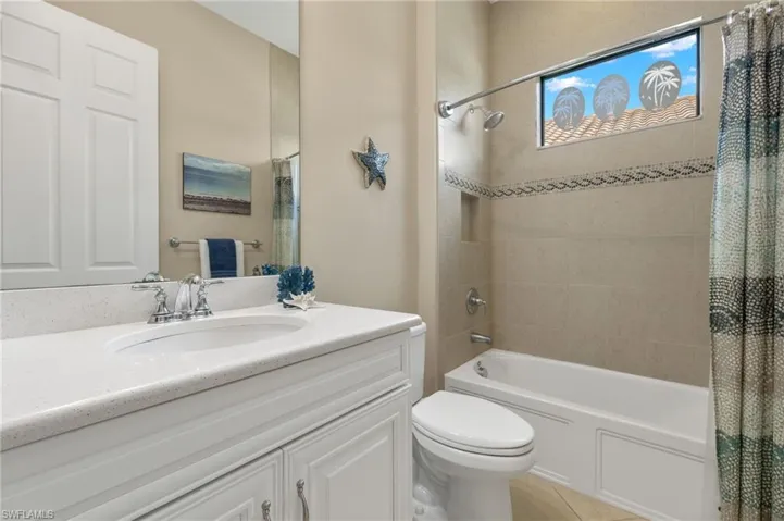 Full bathroom featuring vanity, toilet, shower / tub combo with curtain, and tile patterned floors