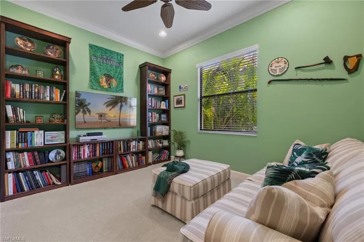 Sitting room with carpet flooring, ceiling fan, and crown molding
