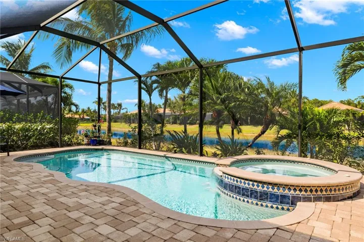 View of swimming pool featuring a lanai, an in ground hot tub, a water view, and a patio
