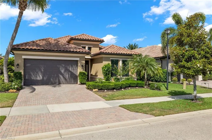 Mediterranean / spanish house with a front yard and a garage