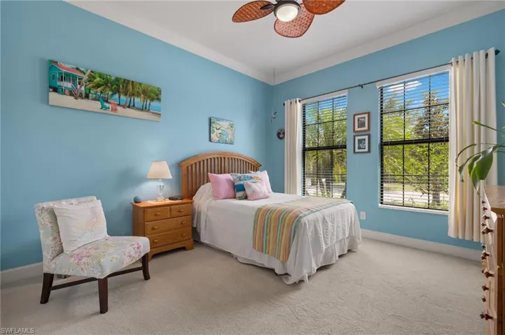 Bedroom with ceiling fan, carpet, and ornamental molding