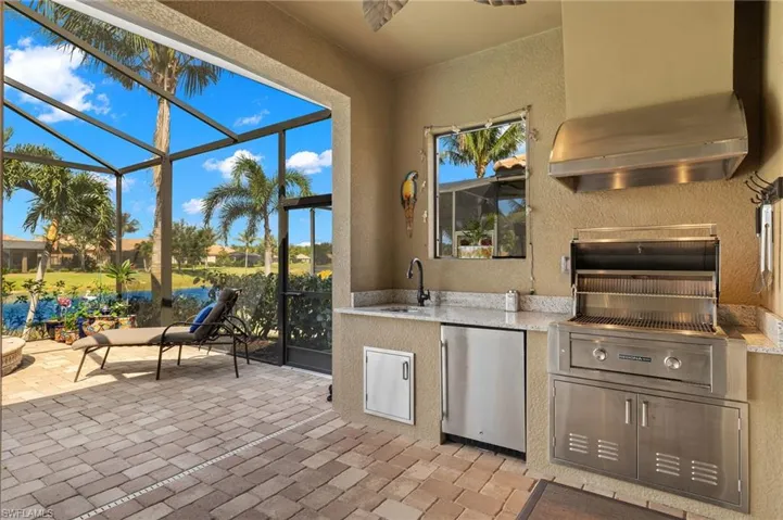 View of patio featuring area for grilling, sink, and a lanai