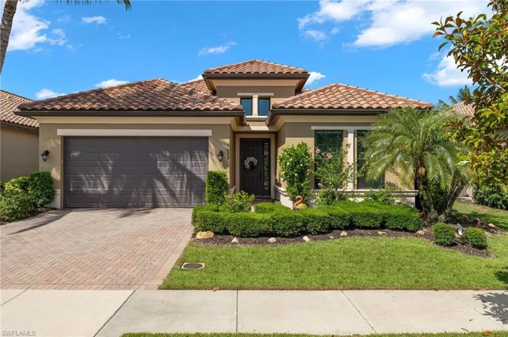 Mediterranean / spanish-style home with a front yard and a garage