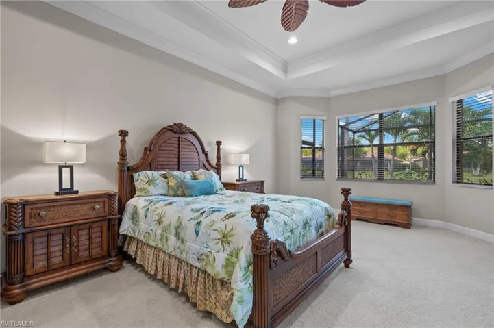 Bedroom with ceiling fan, crown molding, and light carpet