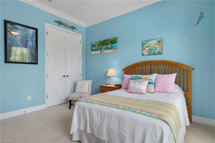 Bedroom with crown molding, a closet, and light colored carpet