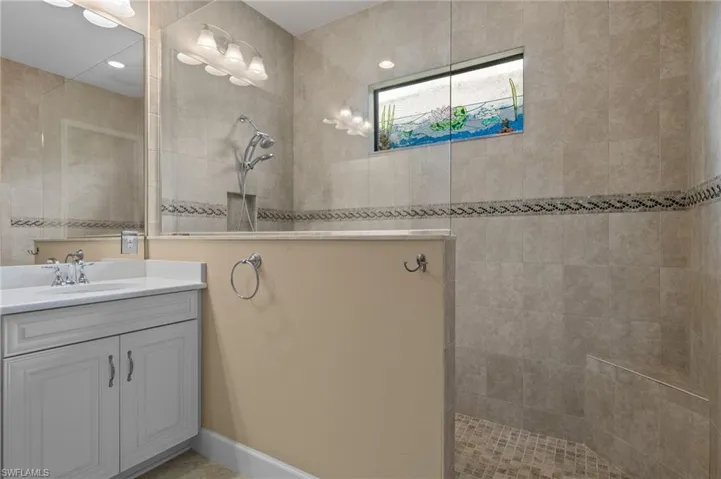 Bathroom with vanity and tiled shower