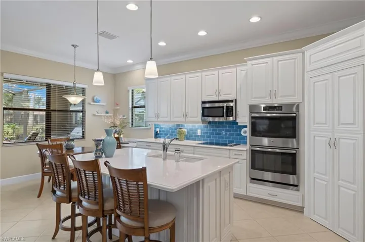 Kitchen featuring a wealth of natural light, white cabinets, appliances with stainless steel finishes, and sink