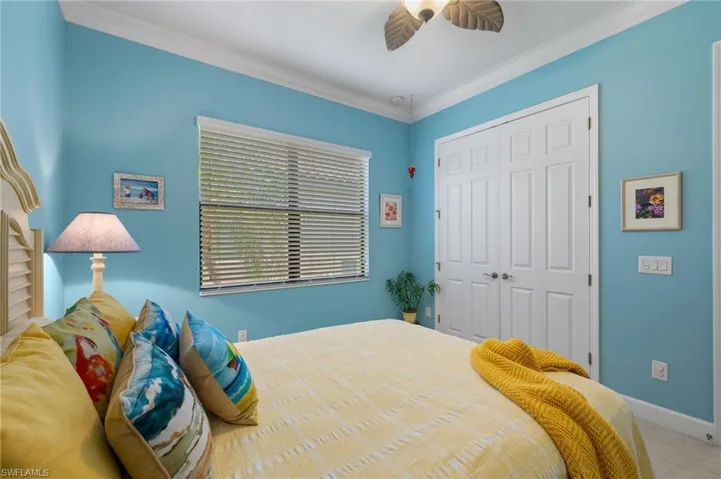 Bedroom featuring a closet, ornamental molding, ceiling fan, and carpet flooring