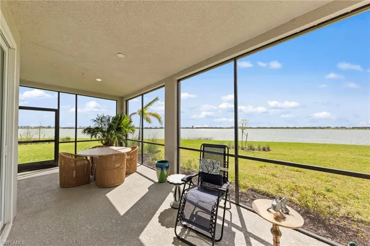 Sunroom featuring a textured ceiling and a water view