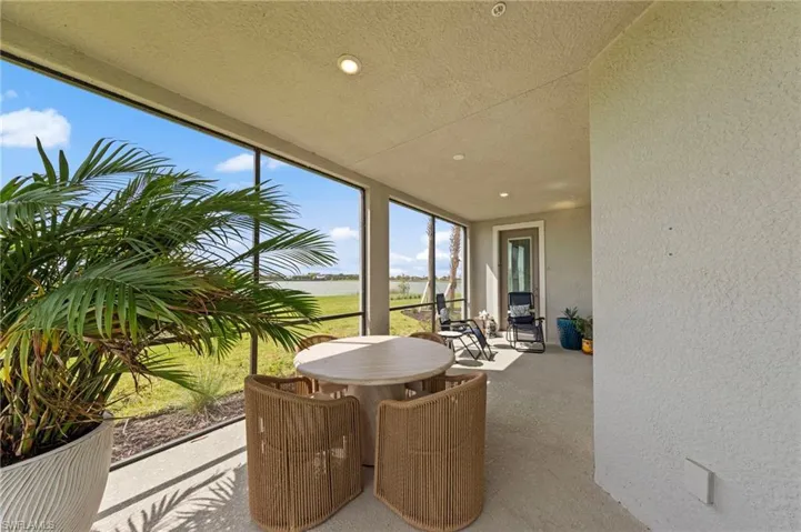 Sunroom / solarium featuring a textured wall, expansive windows, a textured ceiling, and recessed lighting