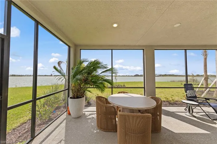 Sunroom / solarium featuring a water view, recessed lighting, a textured ceiling, and healthy amount of natural light