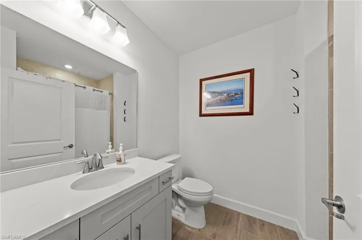Full bath featuring vanity, dark wood finished floors, and a shower with curtain