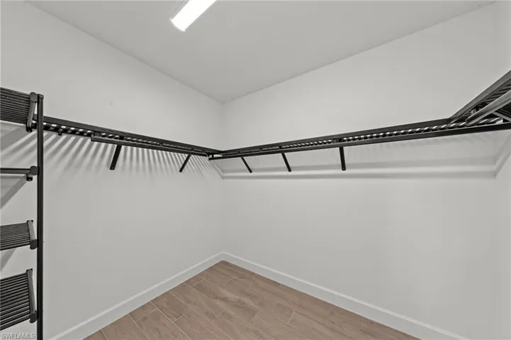 Walk in closet with wood finish floors