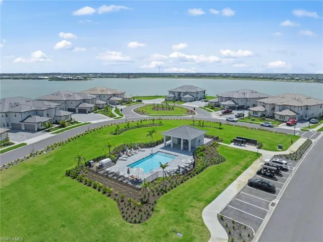 Aerial view of residential area featuring a large body of water and a pool area