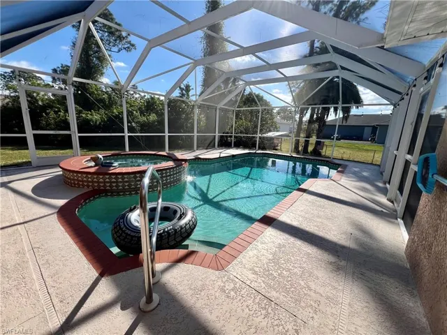 View of pool featuring a lanai, an in ground hot tub, and a patio