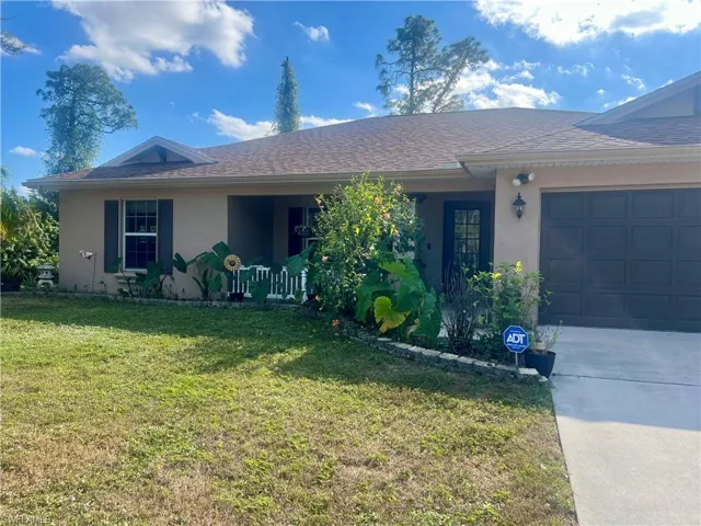 Ranch-style home with a garage and a front lawn