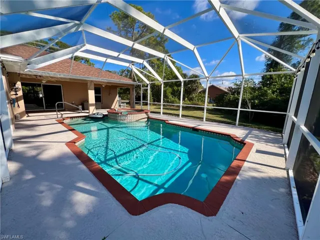 View of pool with a lanai, an in ground hot tub, and a patio