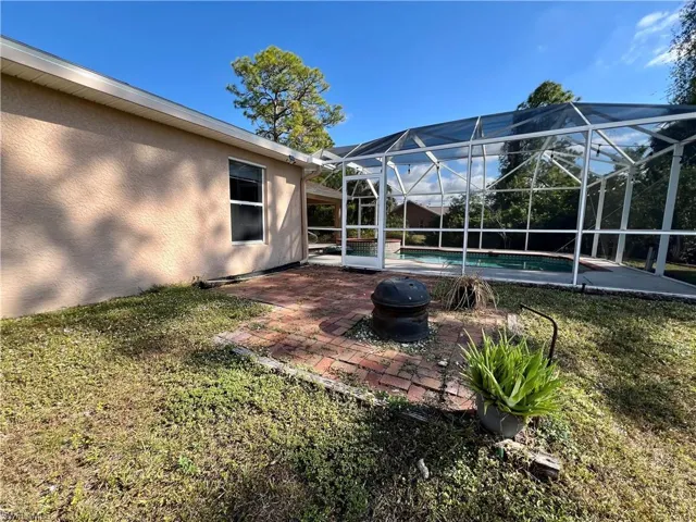 View of yard with a fire pit and a lanai