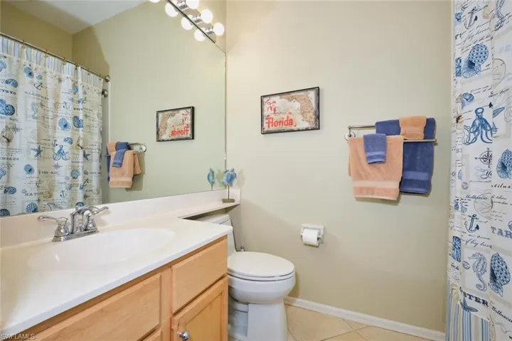 Full bath featuring vanity, a shower with shower curtain, and light tile patterned floors