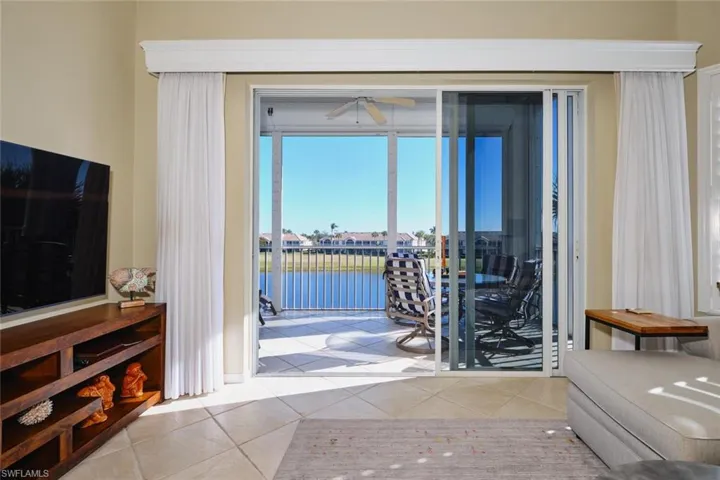 Entryway featuring a ceiling fan, tile patterned floors, and a water view