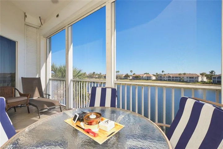 Sunroom featuring a water view, tile patterned floors, and a residential view