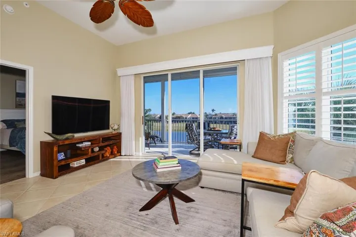 Living area featuring ceiling fan and light tile patterned flooring