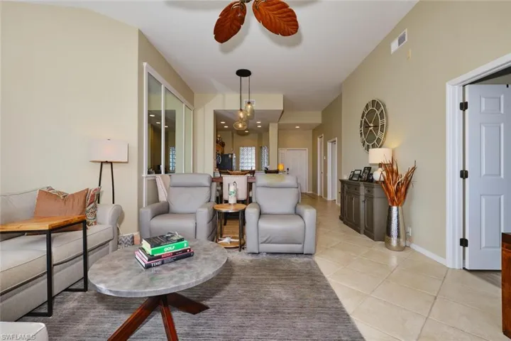 Living room with light tile patterned flooring and a ceiling fan