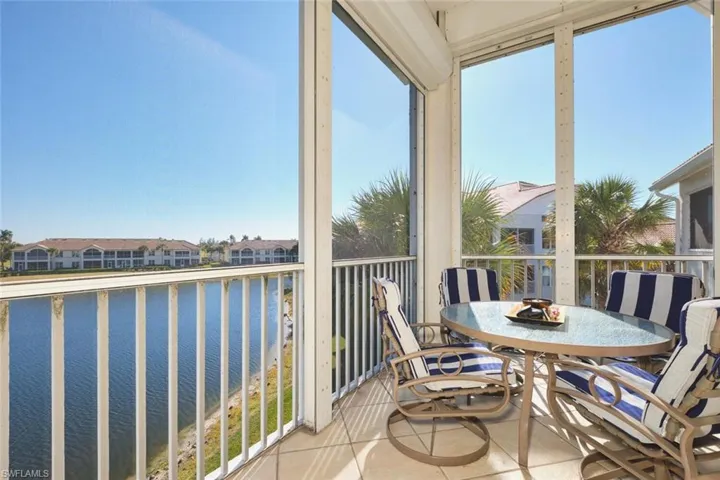 Sunroom featuring a water view, tile patterned flooring, and plenty of natural light
