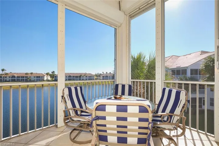 Sunroom / solarium featuring a balcony, a water view, and a residential view