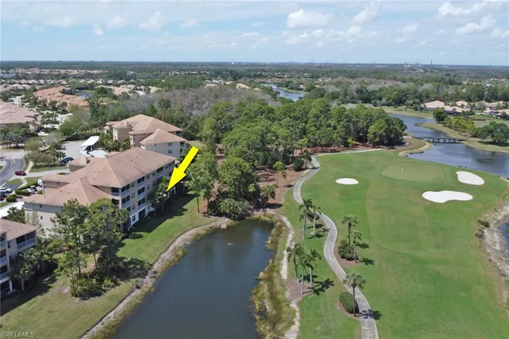 Aerial perspective of suburban area featuring a nearby body of water and a golf course