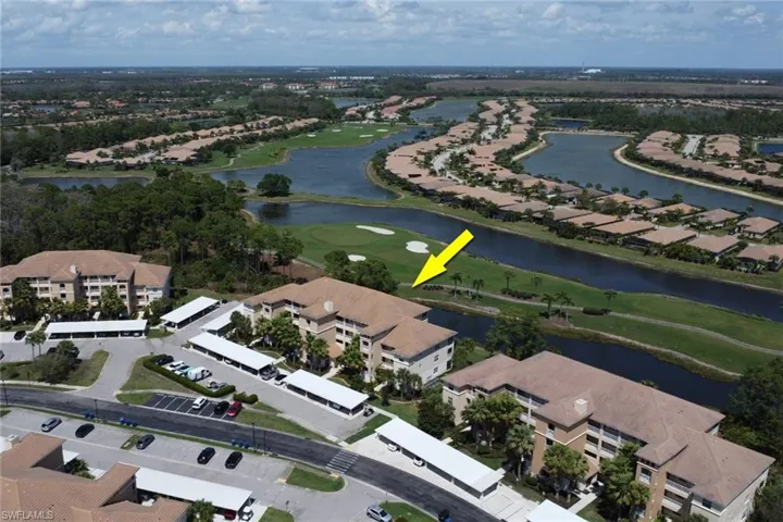 View of property location featuring a golf club, a large body of water, and nearby suburban area