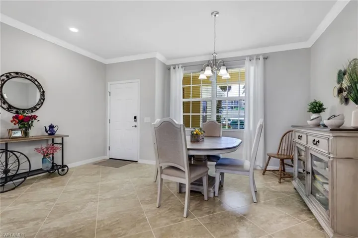Dining space featuring crown molding, a chandelier, and light tile patterned floors