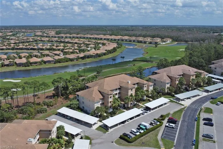 Aerial perspective of suburban area featuring a golf course and a large body of water